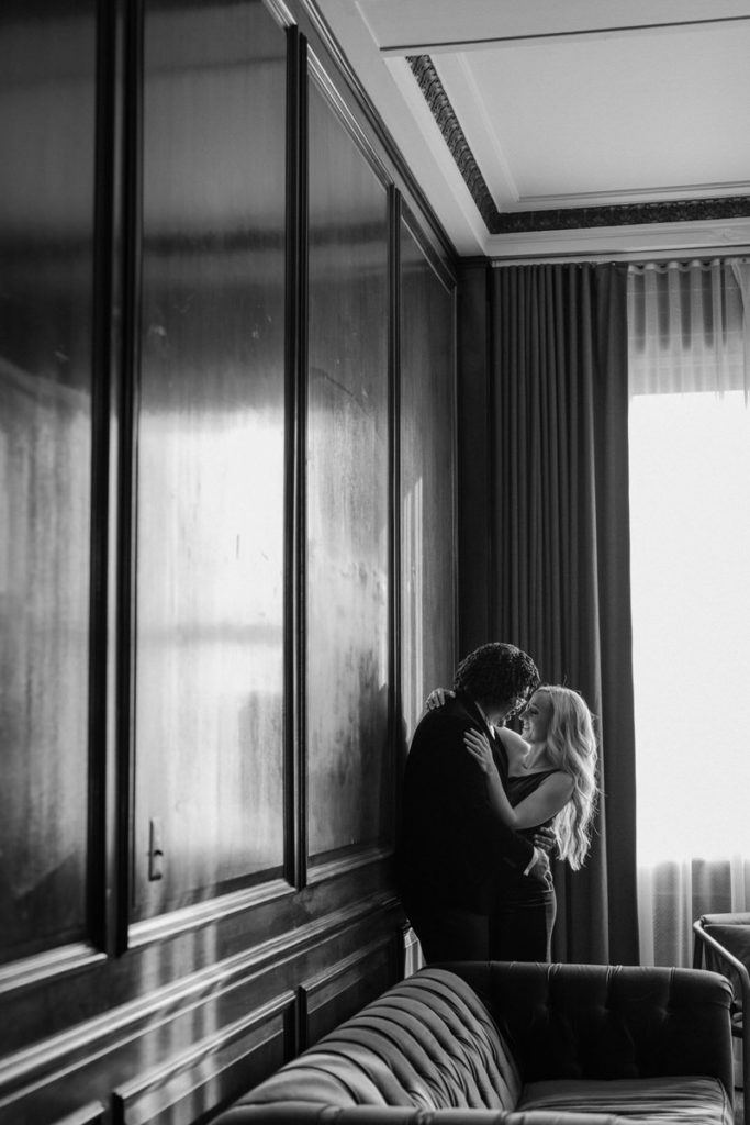 man and woman hugging in the corner of a long room