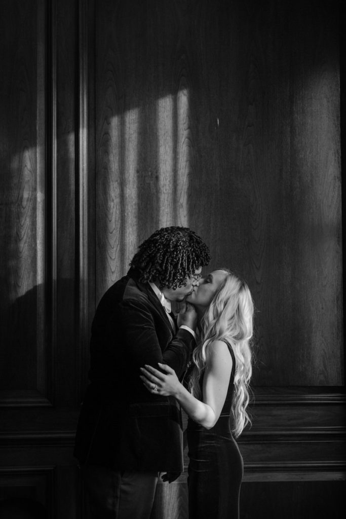 man and woman kissing in a hallway