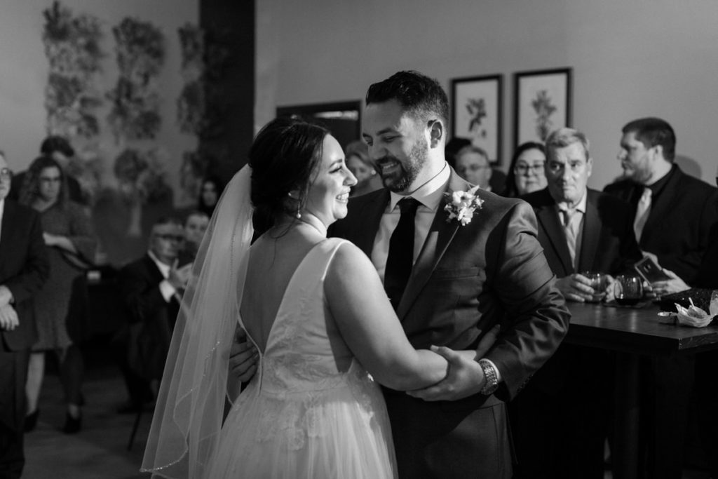 bride and groom dancing while their guests watch them