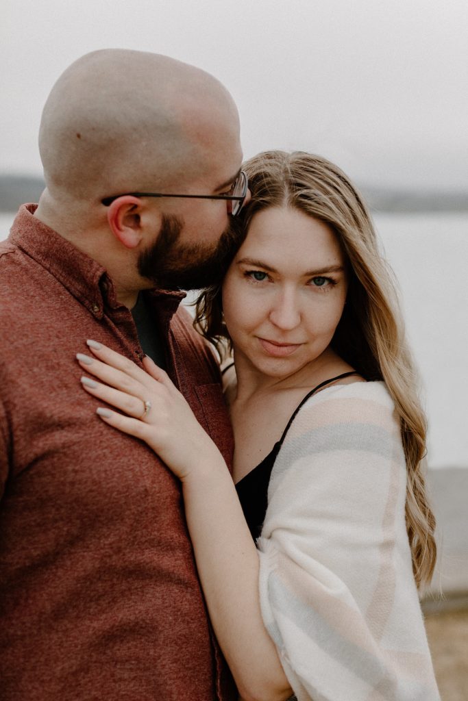 man kissing woman on her forehead