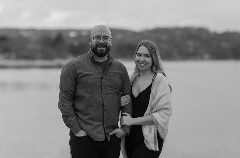 woman with her arm looped through man's while they stand next to each other