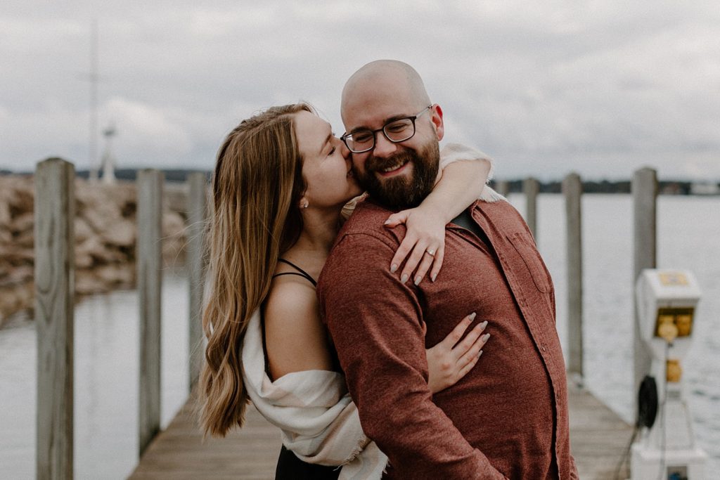 woman kissing man's cheek from behind