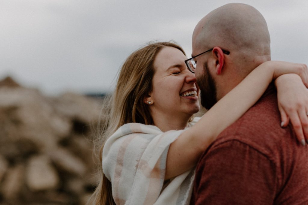 couple with their arms around each other rubbing noses