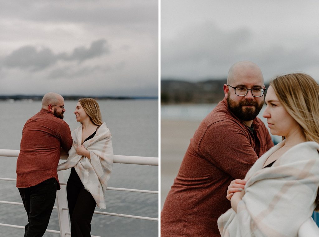 man looking at woman smiling as they lean against a railing over the water