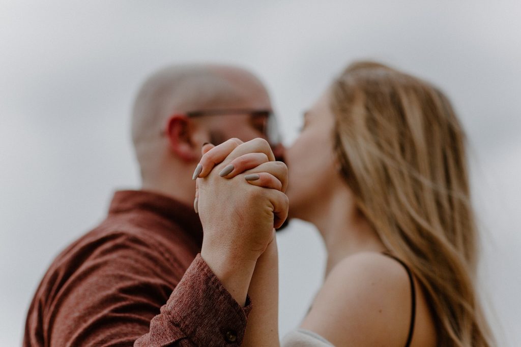 couple holding hands as they kiss each other