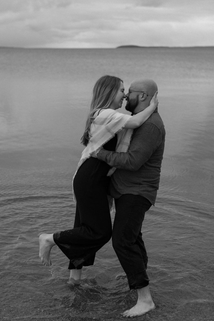 couple standing in shallow water about to kiss