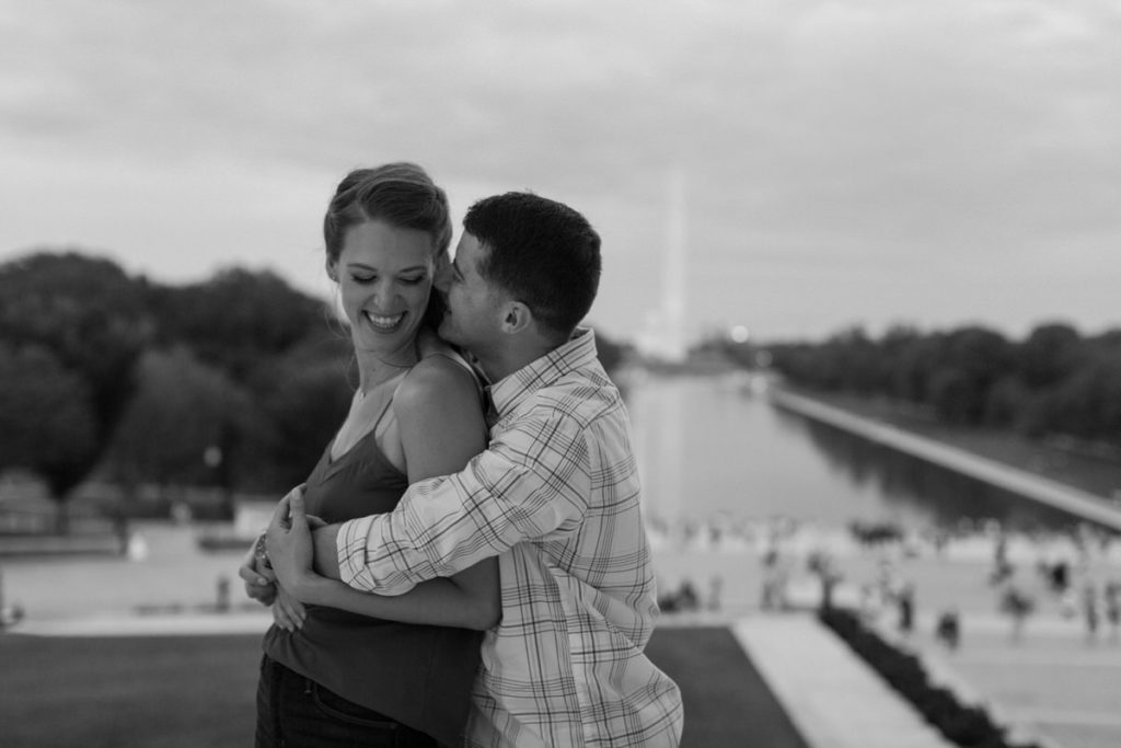 man with his arms wrapped around a woman from behind