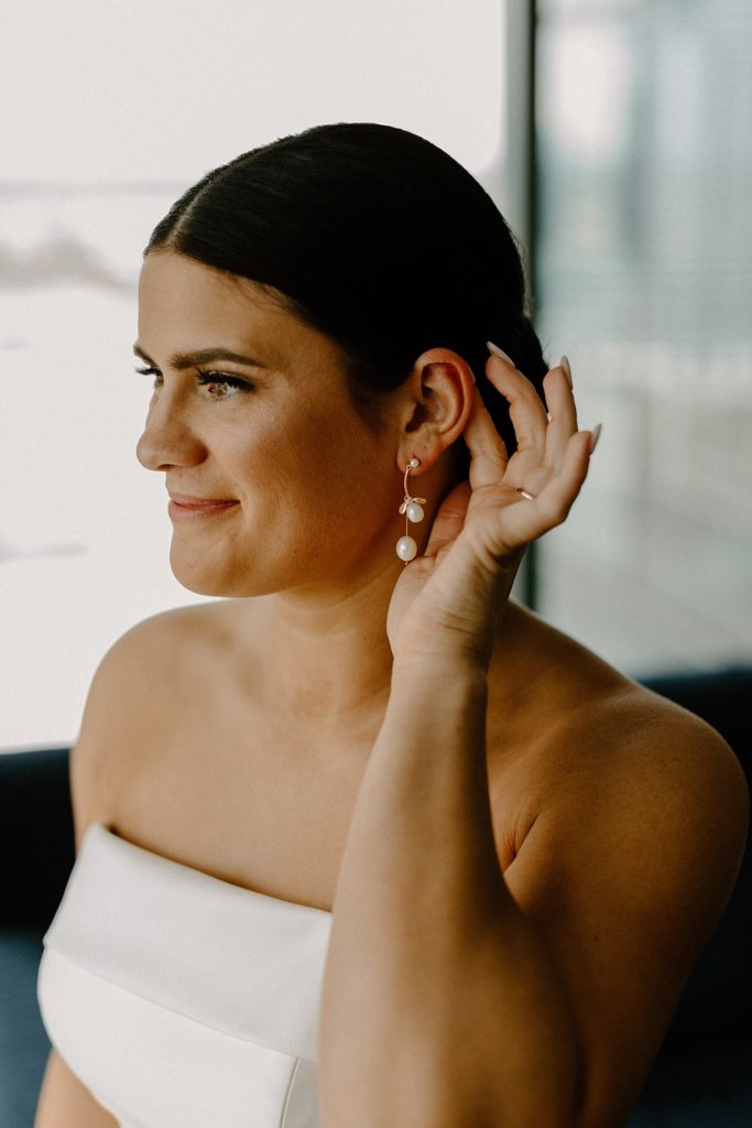 bride showing off earrings on her ear 