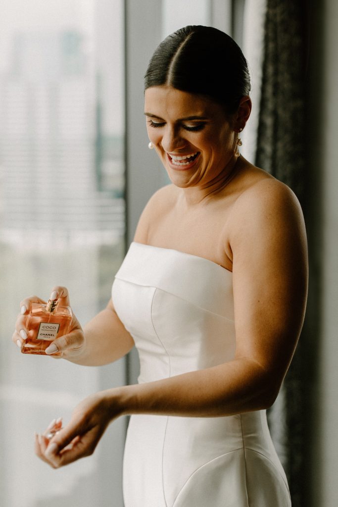 bride spraying perfume on her wrist 