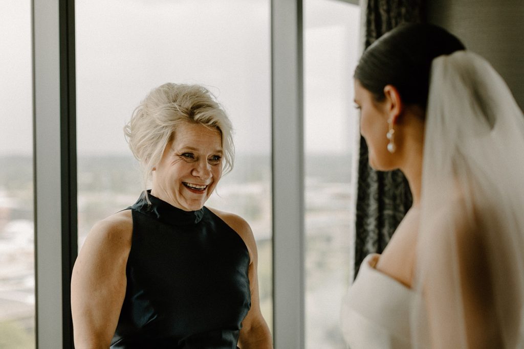 mother and bride smiling at each other 