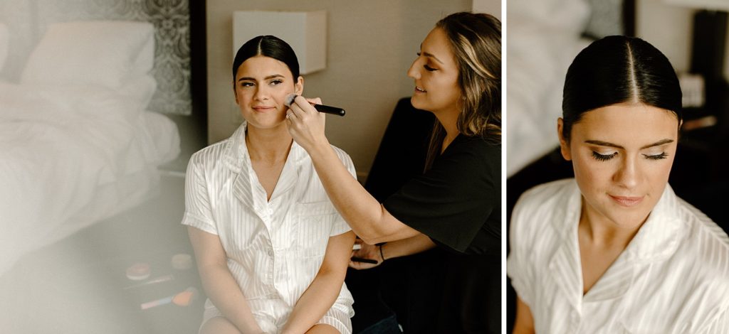 makeup artist putting blush on the bride's face 