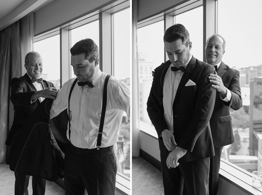 father helping groom put on his suit jacket 