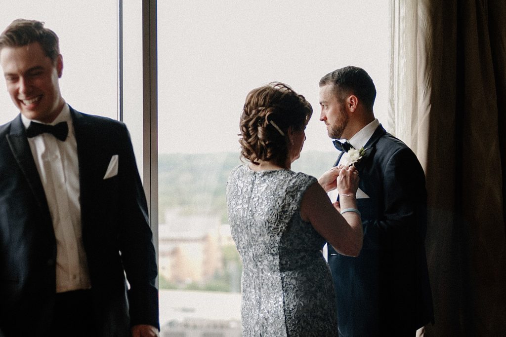 mother helping groom with his suit 