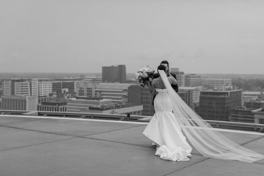 bride and groom kissing on a rooftop 