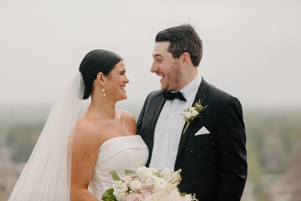 bride and groom looking at each other and laughing 