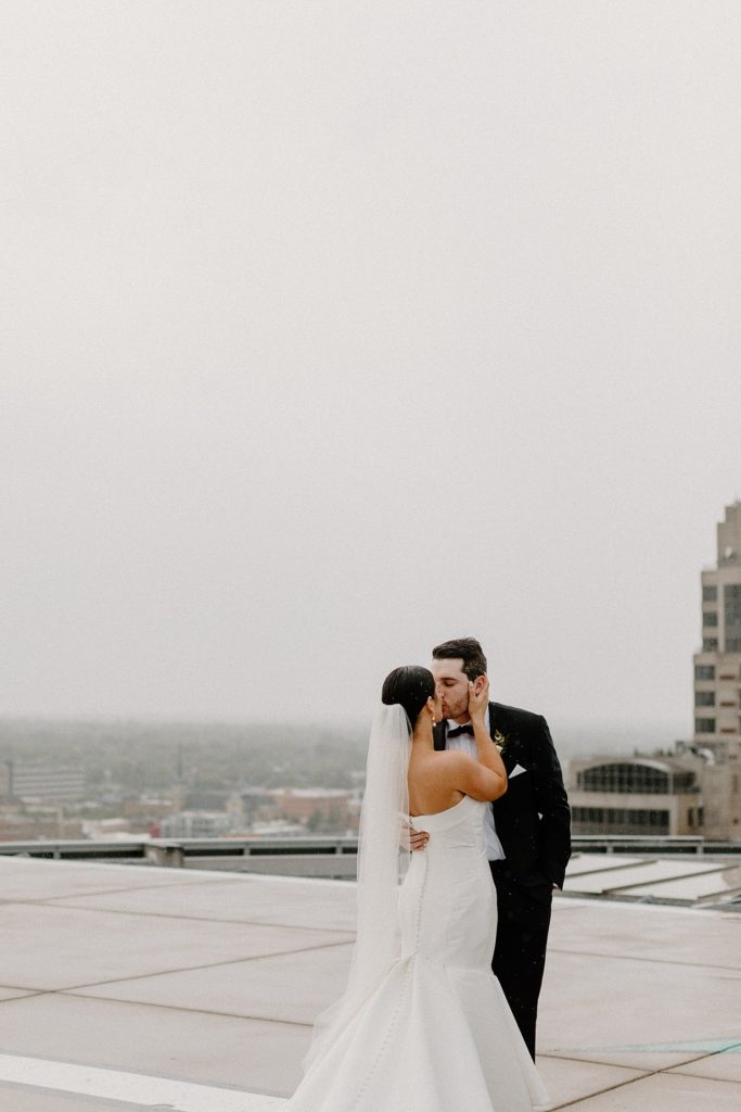 couple kissing while his hands are on her waist 