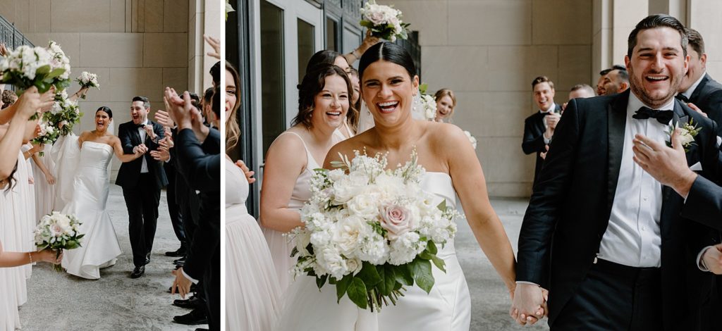 couple holding hands and smiling as they walk between their wedding party 