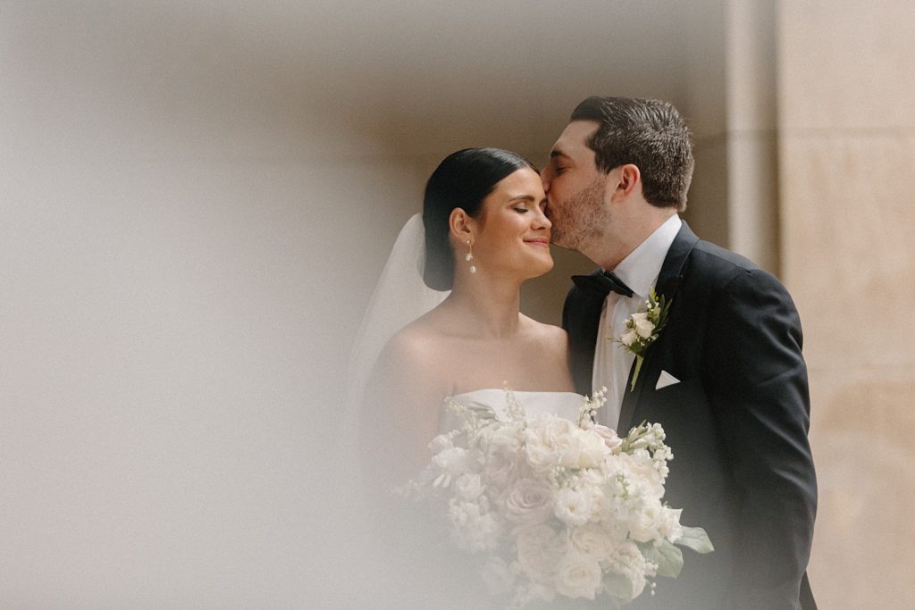 groom kissing bride on her forehead 