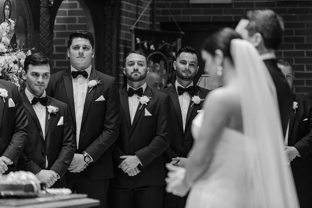 groomsmen looking towards couple standing together 