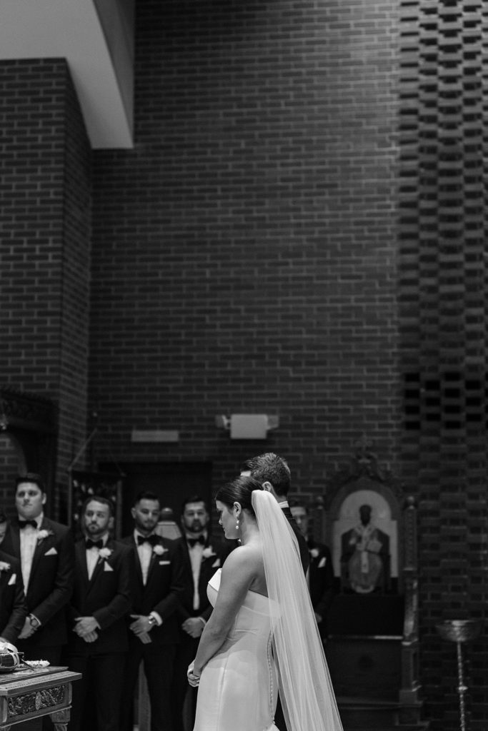 black and white photo of couple standing on the altar 