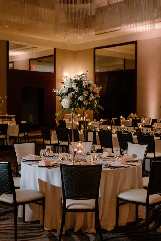 large flower arrangement in the middle of a circular reception table 