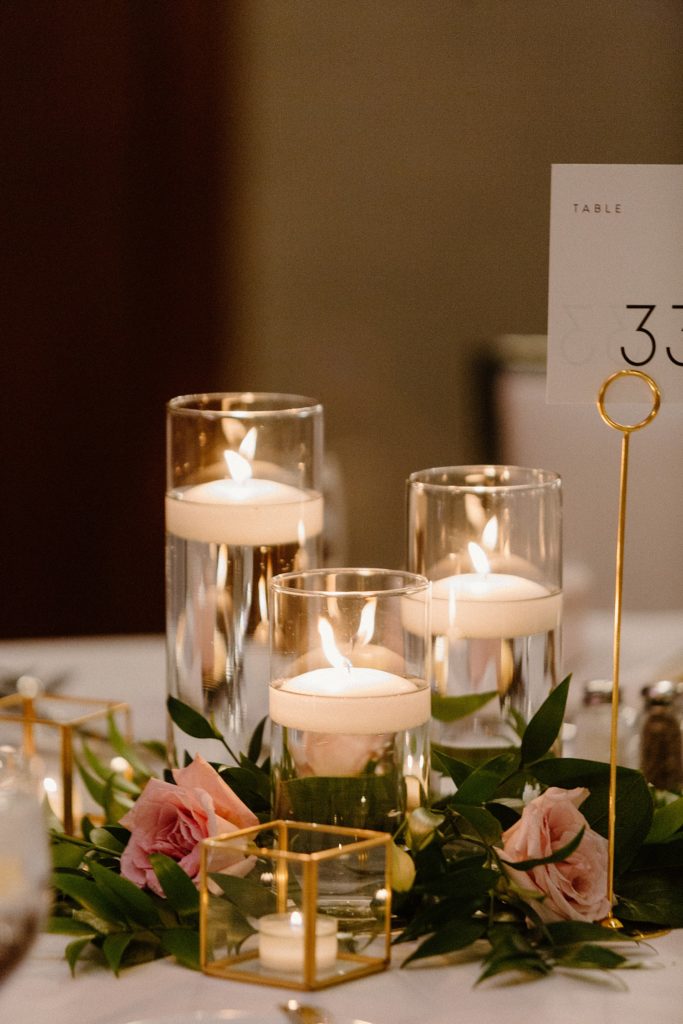 three small tea candles floating in glasses filled with water 