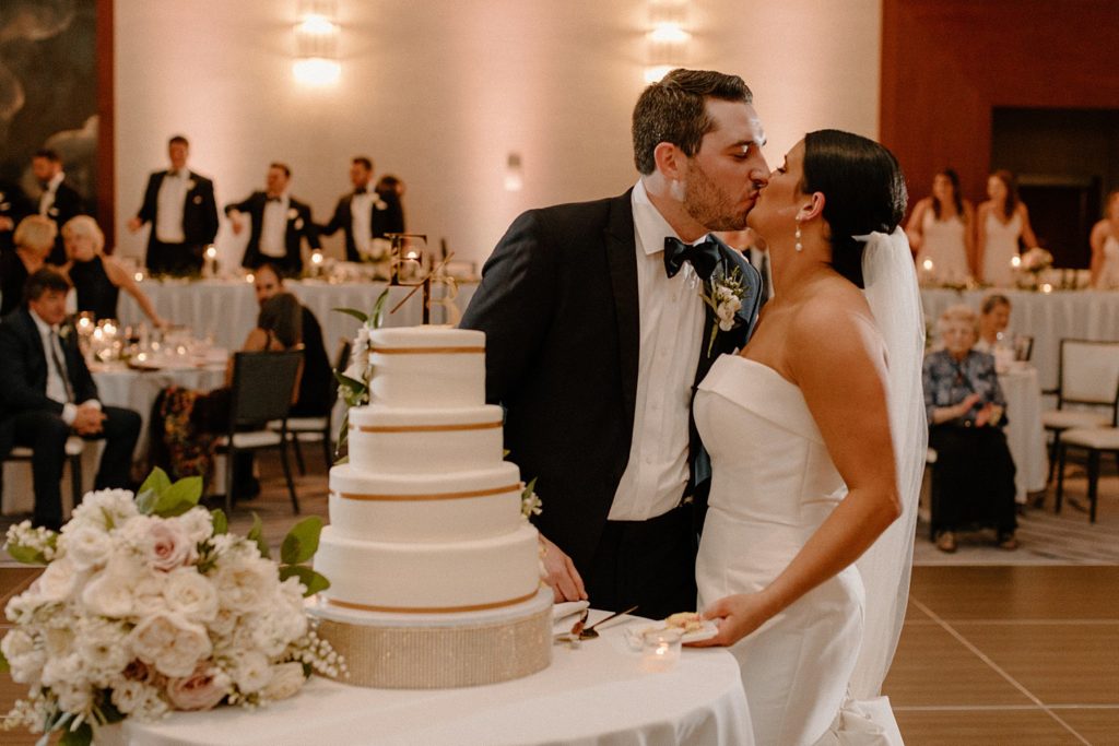 couple kissing after cutting their cake 