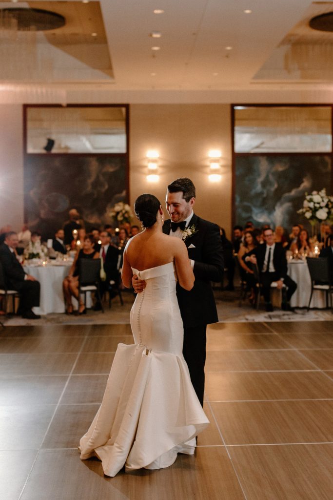 bride and groom holding each other dancing 