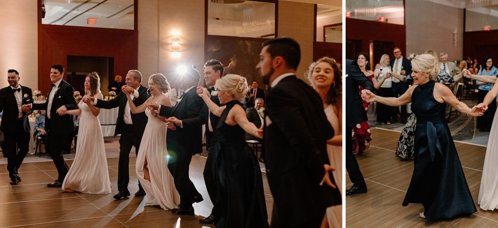 wedding guests standing in a circle dancing 
