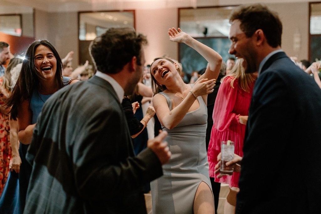 guests smiling and dancing in a circle 