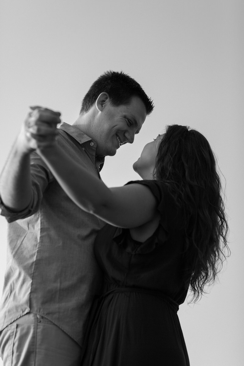 couple holding hands outstretched while smiling at each other