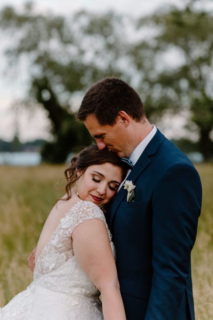 couple hugging while woman leans her head on man's chest