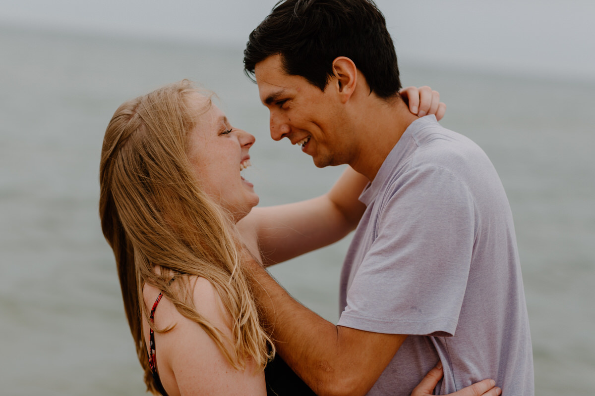 couple holding each other's faces and laughing