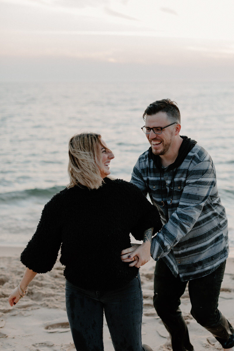 man reaching for woman from behind as they laugh together