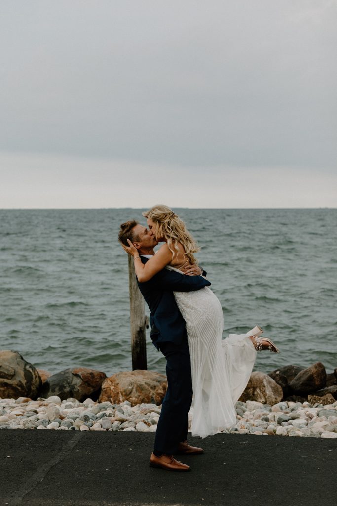 groom holding bride up as they kiss