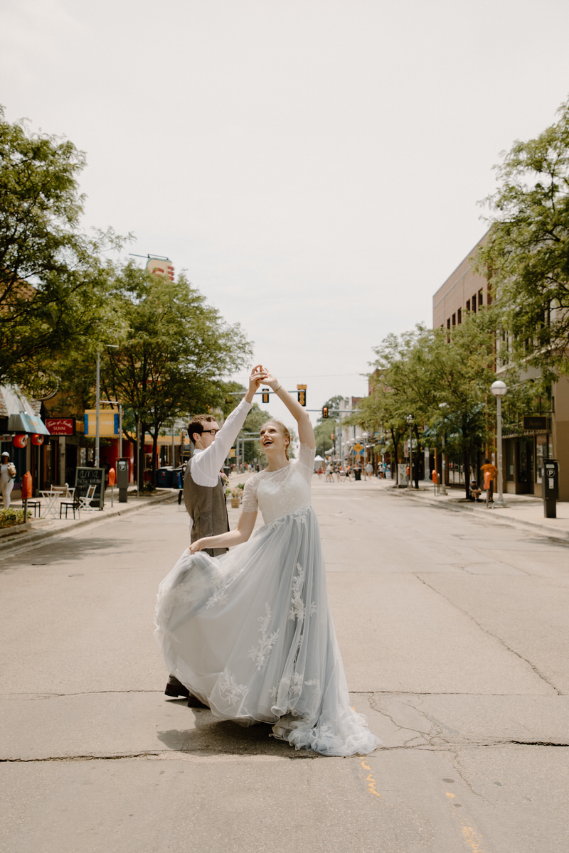 groom twirling bride in the middle of the street