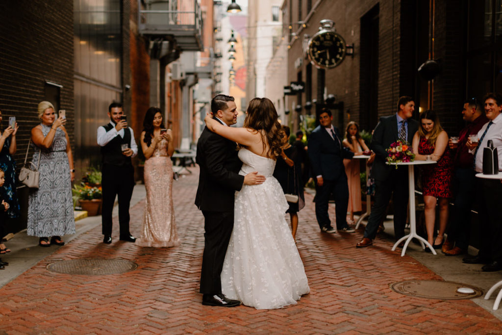 couple dancing in a city street with their friends around them