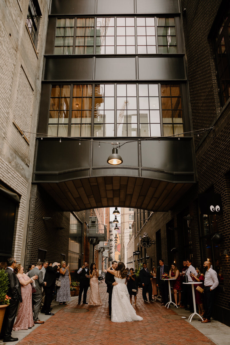 wedding couple dancing in an alleyway in the city