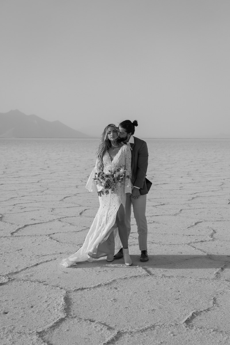 man hugging woman from behind and kissing her cheek