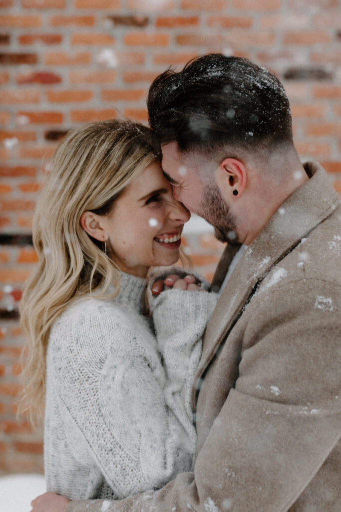 couple with their arms around each other as they touch foreheads