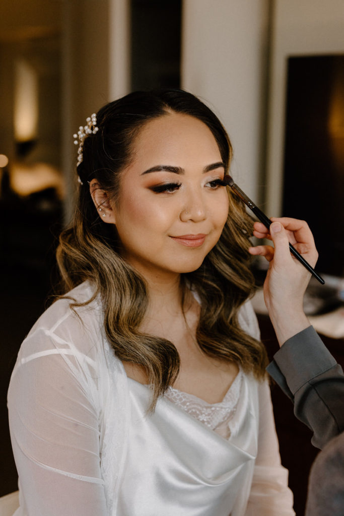 getting ready wedding photo of a bride getting her make up done