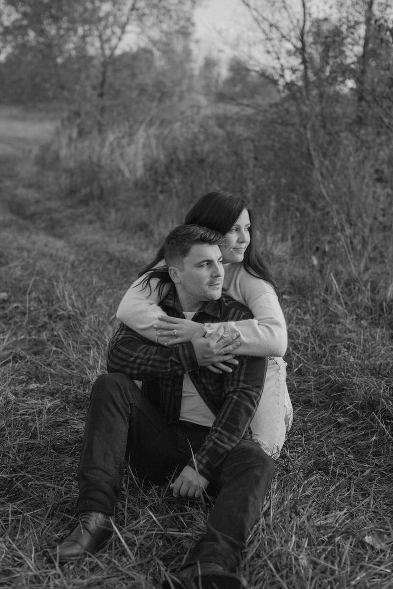 featured image for the best CRM for photographers featuring a couple sitting behind each other looking off to the side with their arms around each other